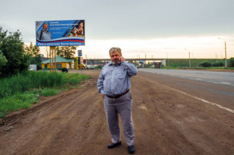 Анатолий Ехалов на фоне баннера по итогам проекта «Имя в культуре Вологодчины». Фото из личного архива